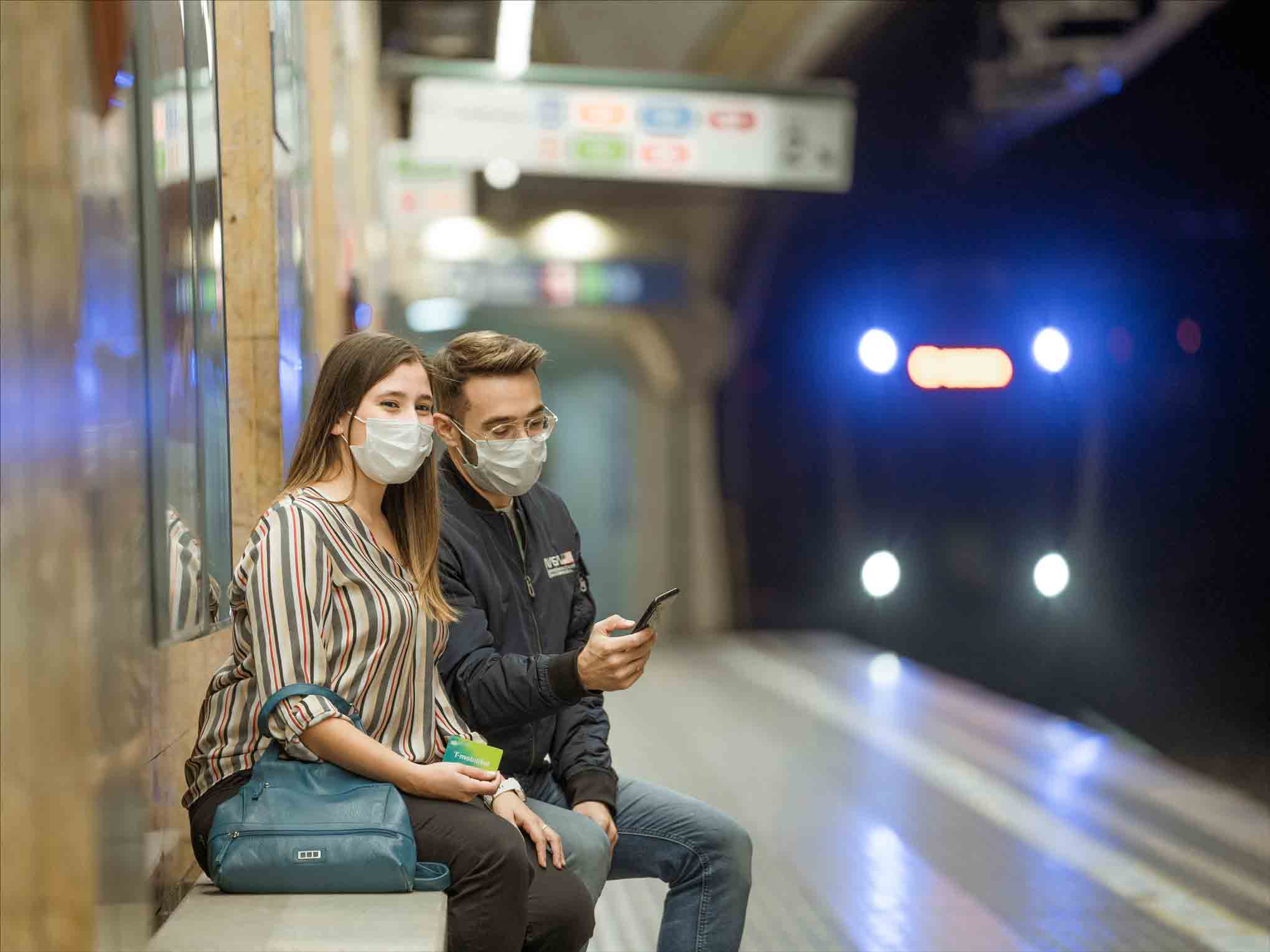 Dues amigues parlen de la T-mobilitat en una andana de tren.