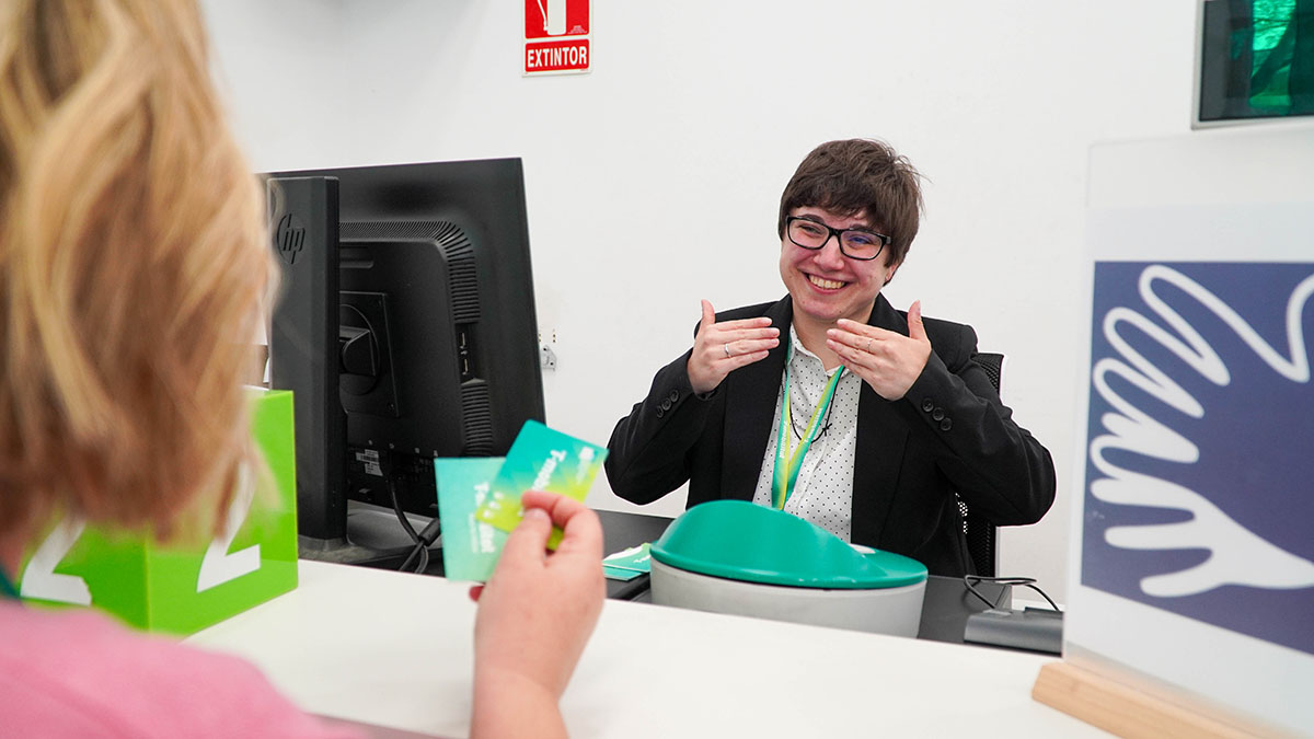 Una agent atén a una usuària en llengua de signes.