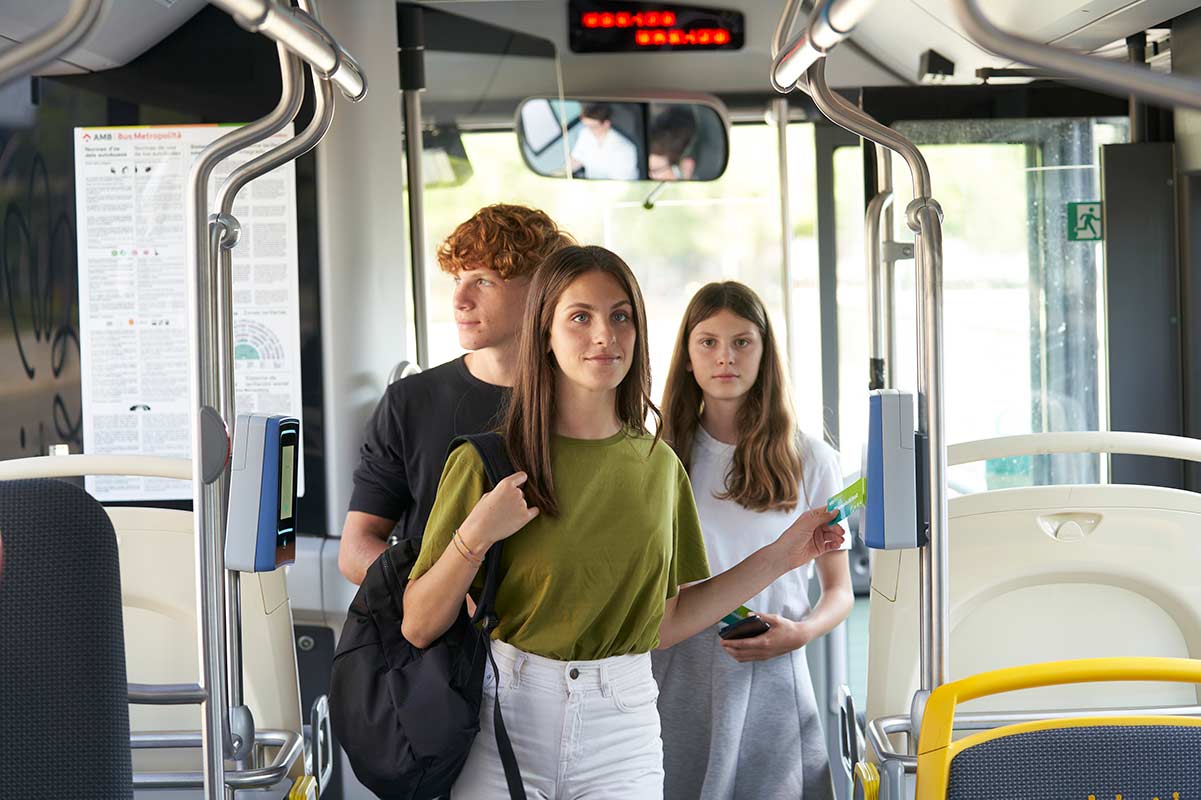 Three young people entering on a bus.