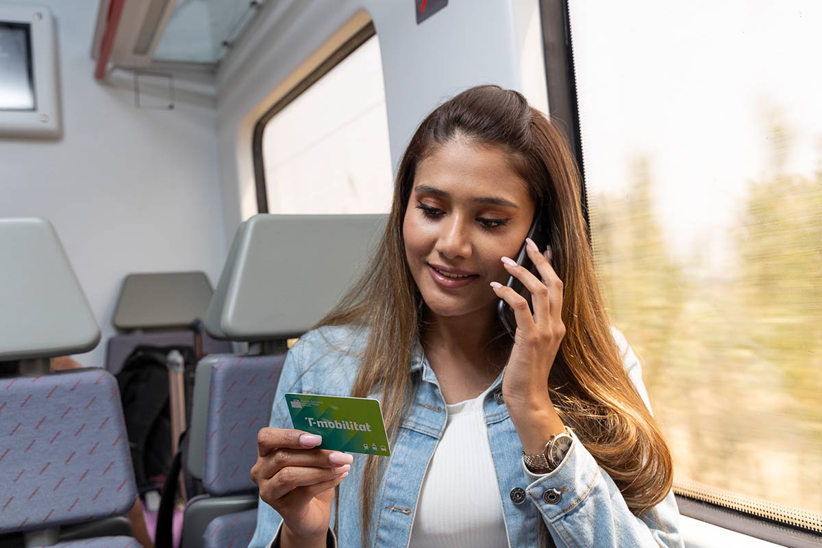 Una chica llama por teléfono con su T-mobilitat en la mano